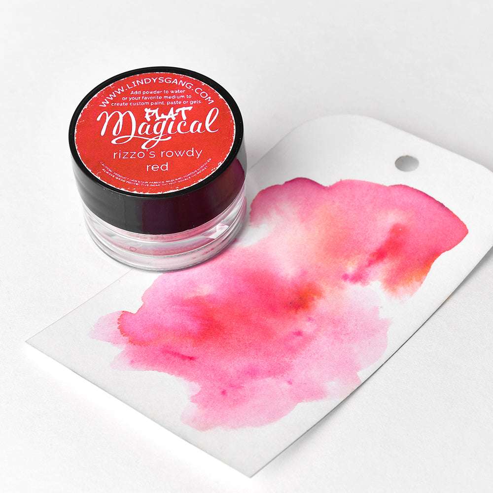 Eine Dose Lindy's Stamp Gang Rowdy Red Magical Powder steht neben einem weißen Anhänger mit einem rosafarbenen Aquarellmuster - ideal, um leuchtende Farbmischungen zu erstellen.