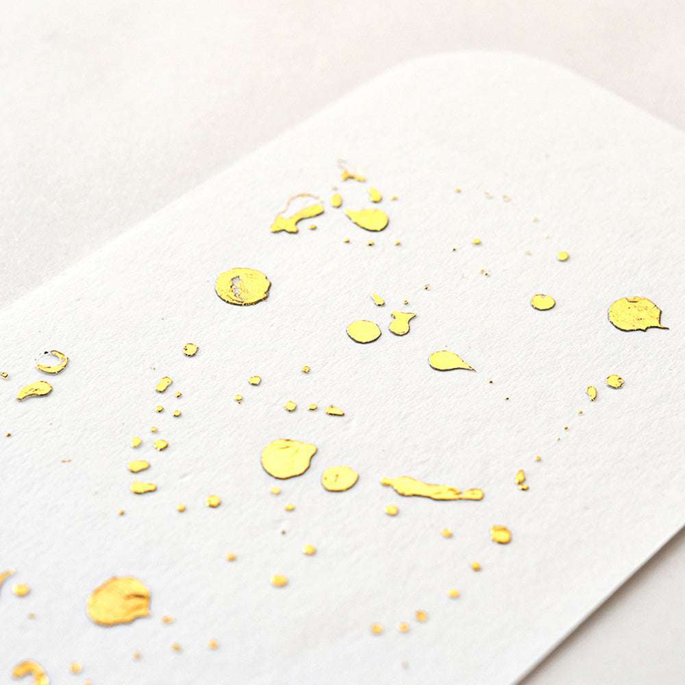 ☆ weißes Papier mit eingestreuten Helles-Gold-Folienpunkten, schräg auf hellem Hintergrund - ideal für Bastelprojekte oder kreative Folientransferideen.