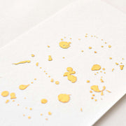 Goldene Farbspritzer auf strukturiertem weißem Papier ergeben ein abstraktes, minimalistisches Design mit einem eleganten matten Kupfer-Gold-Finish von ☆.