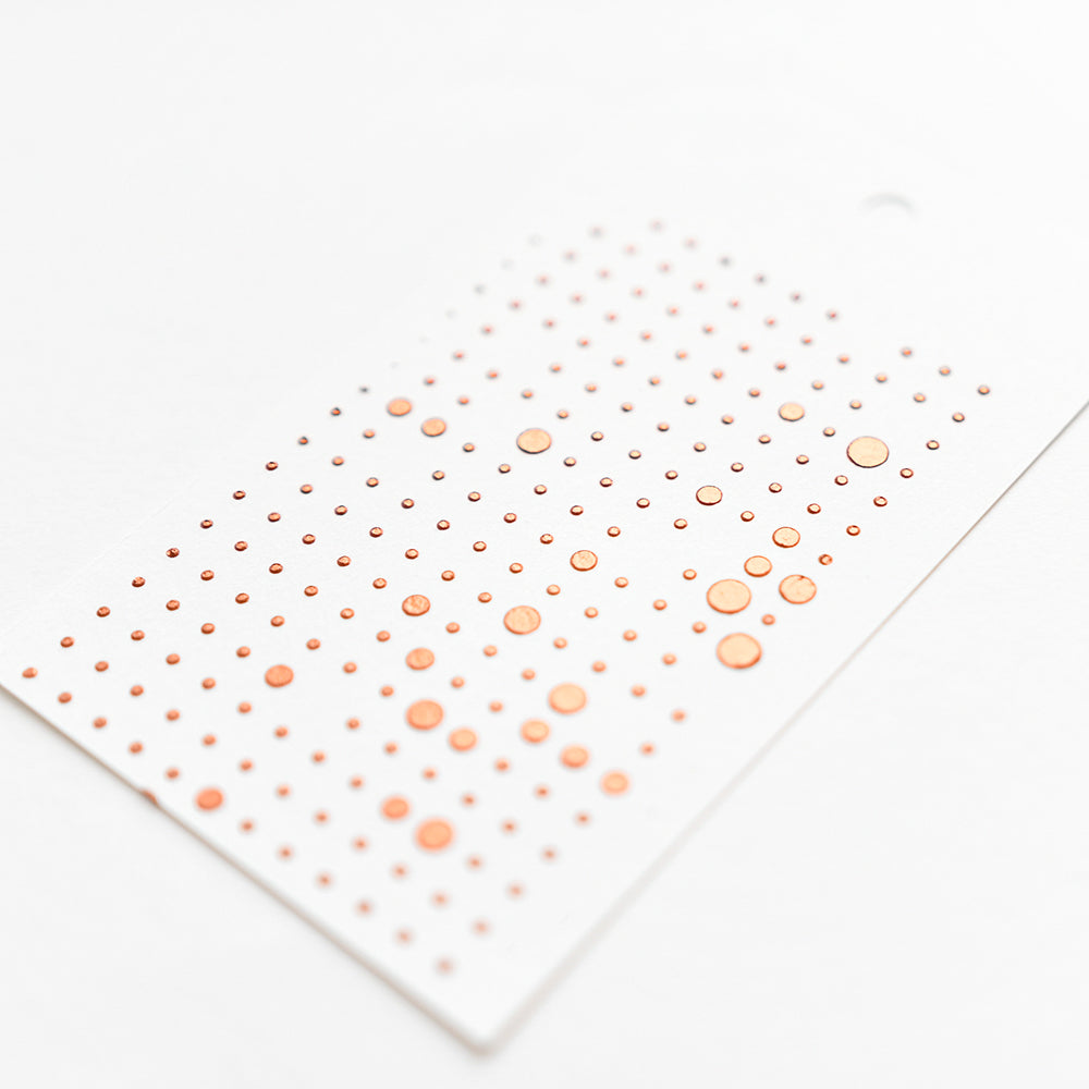 Ein Bogen mit kleinen, runden, metallisch-orangen Alexandra Renke Aufklebern in ordentlichen Reihen auf weißem Papier - ideal für Schablonen-Punktraster-Projekte und wiederverwendbar für verschiedene DIY-Anwendungen.