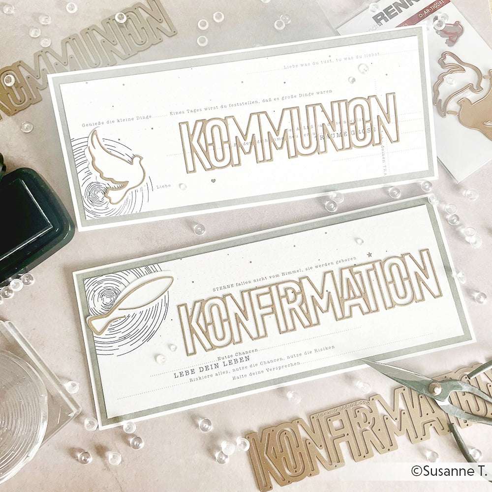 Zwei handgefertigte Karten von Alexandra Renke mit den Texten "KOMMUNION" und "KONFIRMATION", mit Tauben- und Blattmotiven aus Designpapier, sowie Buchbinderei-Werkzeug und Bastelmaterial in der Nähe.
