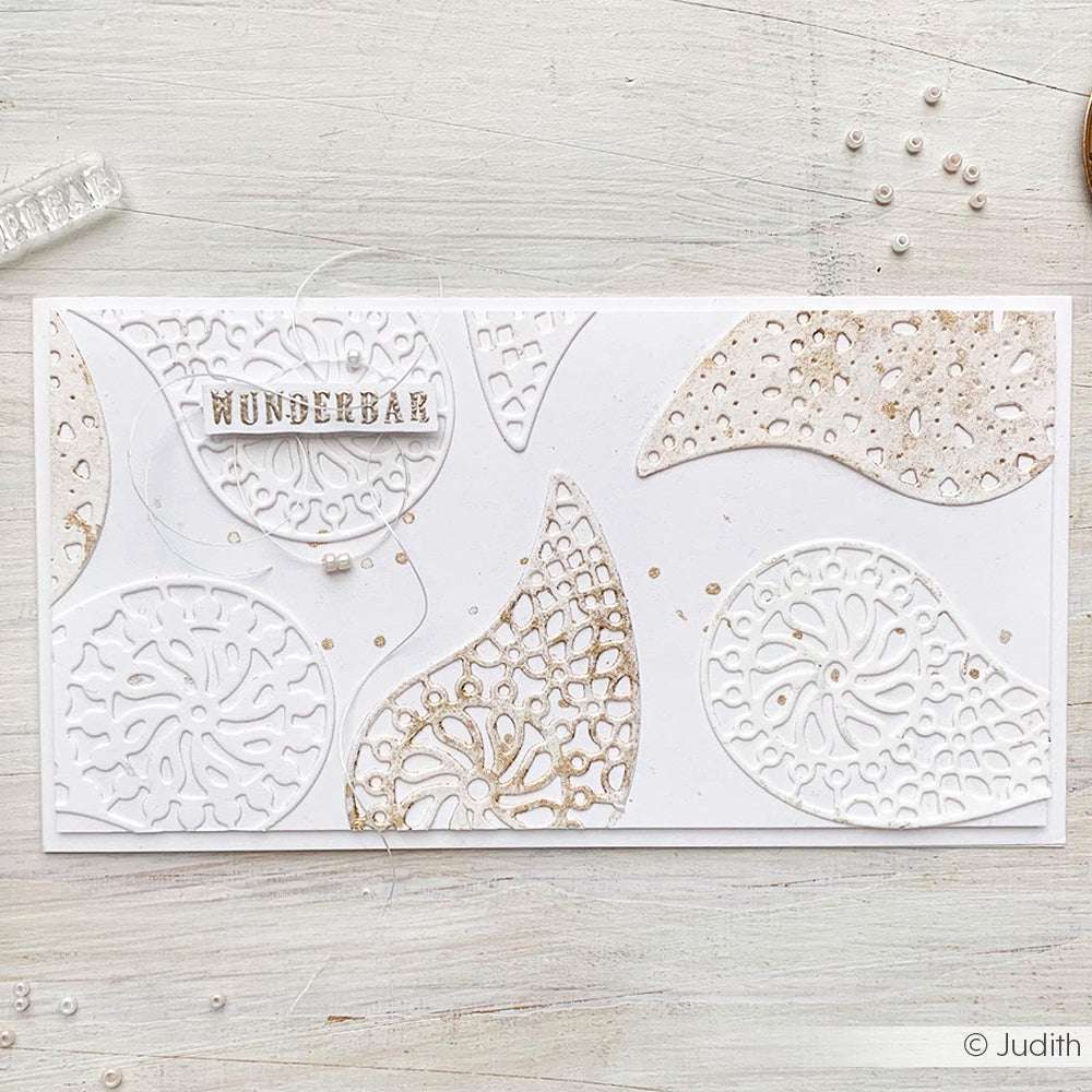 Handgefertigte Karte von Alexandra Renke aus Schichtornament-Filigran mit filigranen weißen und beigen Aussparungen, dem Text "WUNDERBAR" und zarten Paisley-Mustern auf strahlend weißem Hintergrund.