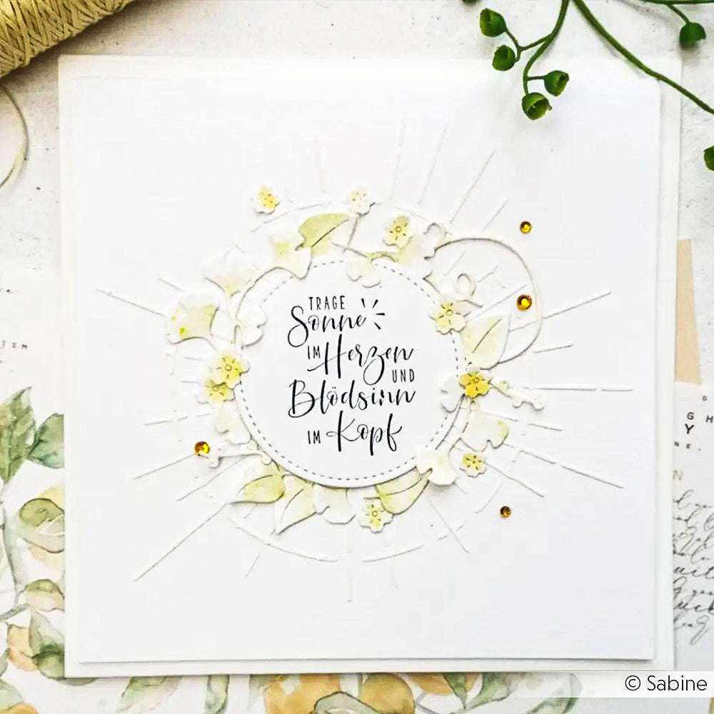 Eine handgefertigte Karte von Alexandra Renke mit floralen Verzierungen, die mit Schablonen und eleganter deutscher Kalligraphie auf weißem Hintergrund gestaltet wurde.