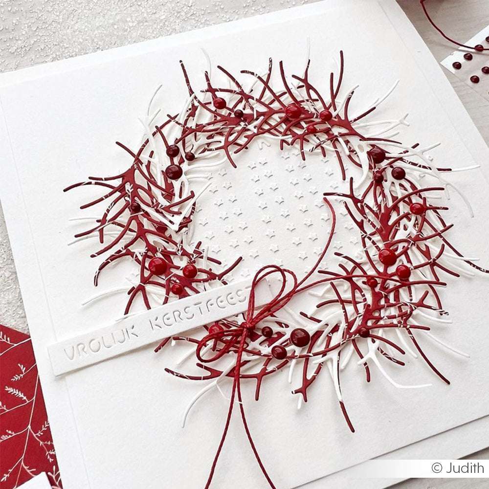 Eine handgefertigte Weihnachtskarte mit rotem und weißem Papierkranz von Alexandra Renke mit dem Etikett "Vrolijk Kerstfeest", mit Schablonen Papierprojekte für eine elegante Note.