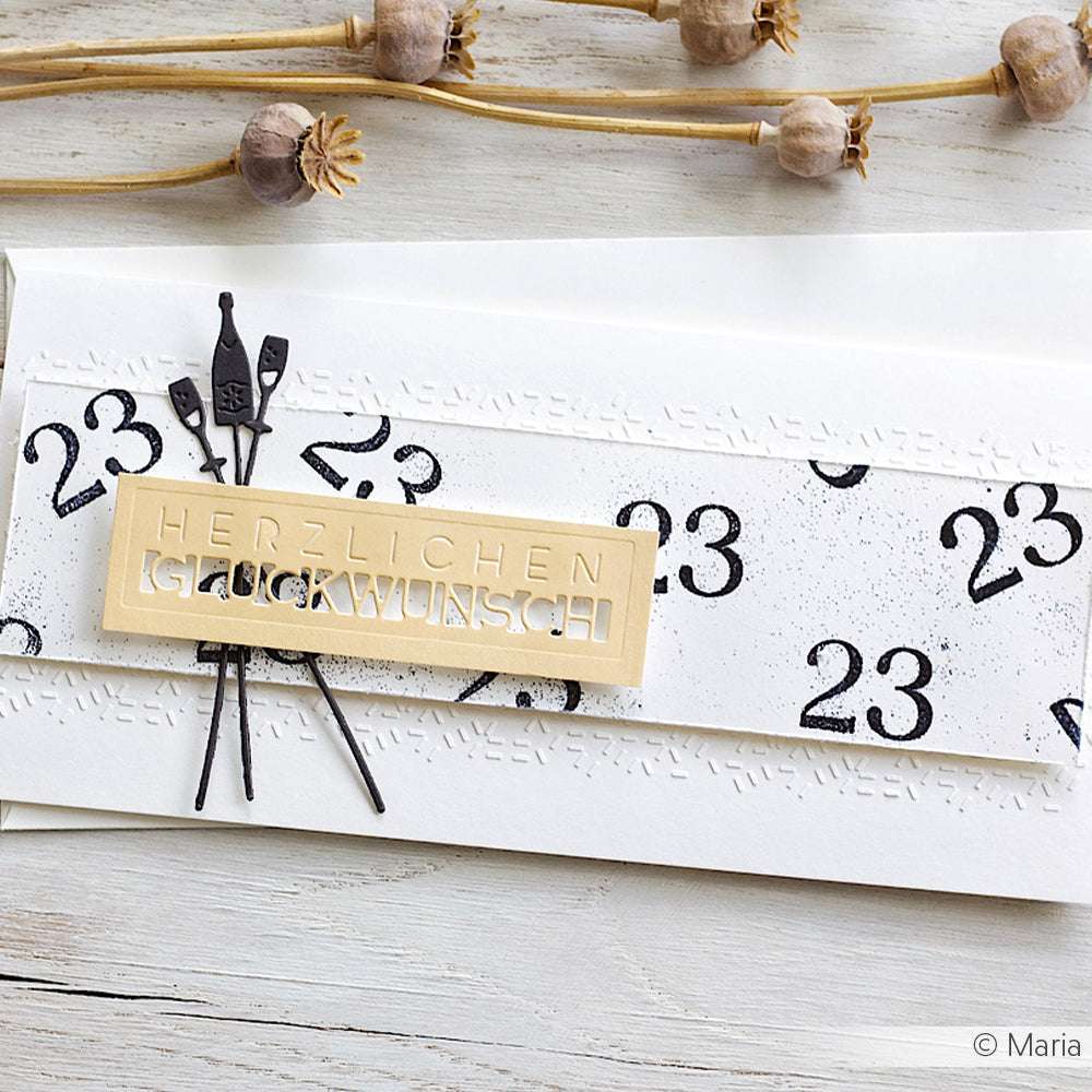 Eine handgefertigte Karte von Alexandra Renke zeigt "Herzlichen Glückwunsch" und die Zahl 23, verziert mit einem Briefumschlag, getrockneten Pflanzen und mit Papierprojekte Schablonen für eine einzigartige Note.