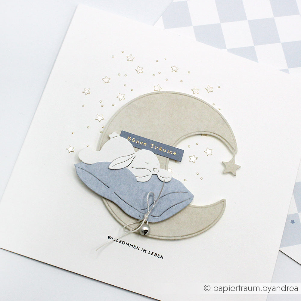 Alexandra Renke Grußkarte mit einem schlafenden Hasen auf einem Kissen über einer Mondsichel, umgeben von Sternen und deutschem Text - ideal für Schablonen Papierprojekte oder zum Basteln mit wiederverwendbaren Stencils.