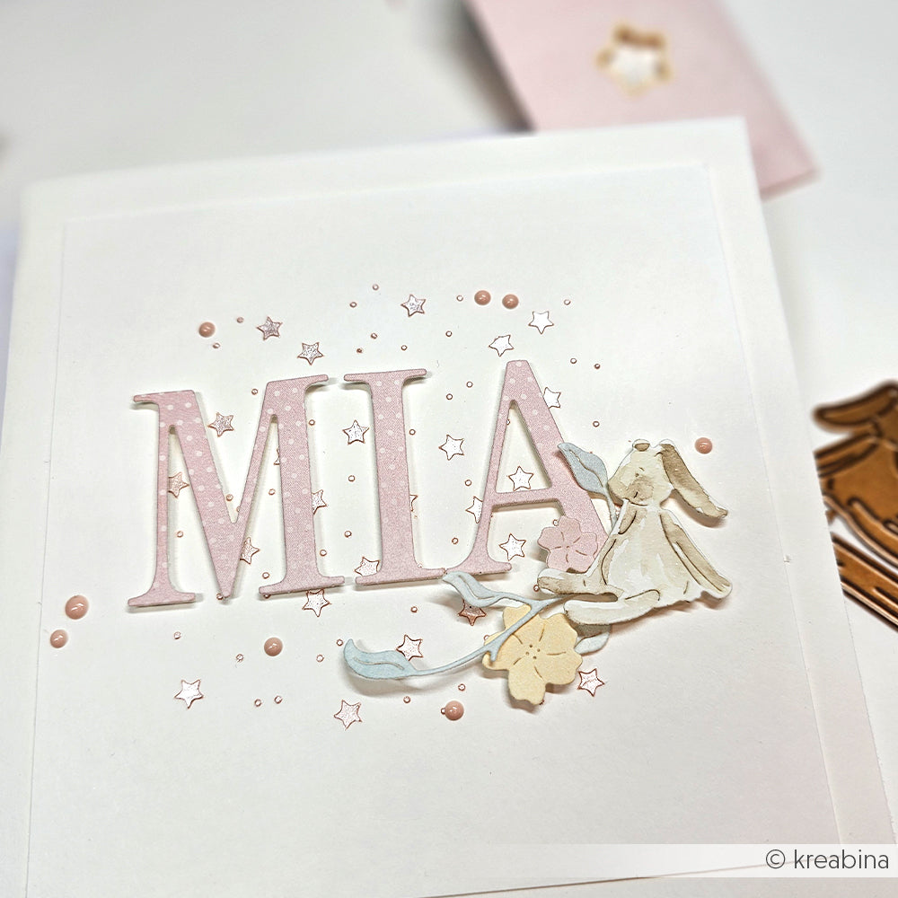 Handgefertigte Karte von Alexandra Renke mit MIA in Rosa, einem Hasen, Blumen und Stern-Akzenten mit Stencil Sternen auf Weiß - ideal für einzigartige Papierprojekte.