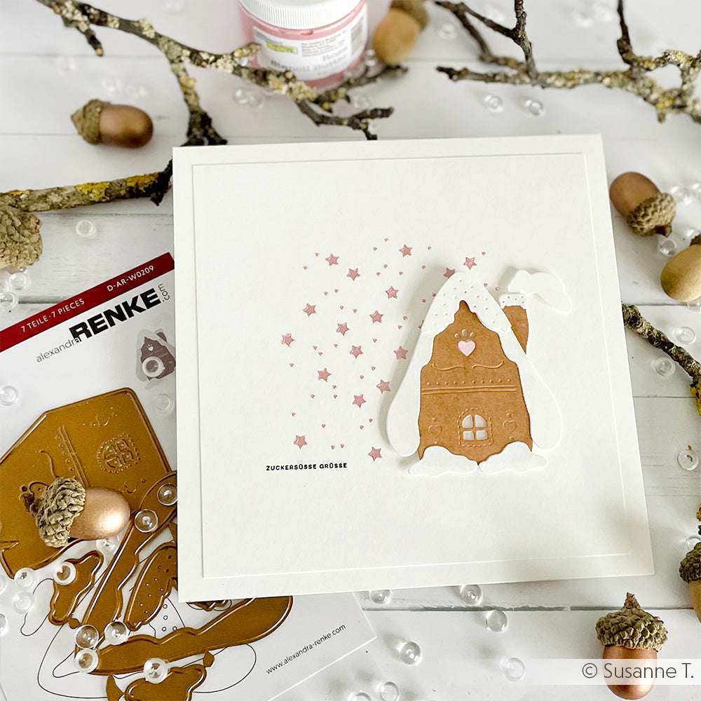 Handgemachte Winterkarte von Alexandra Renke mit einem Lebkuchenhaus, verschneiten Zweigen, Eicheln und Sternen - perfekt für Schablonen Papierprojekte. Die Schablone Sterne ist wiederverwendbar und ideal für verschiedene Winterbasteleien.