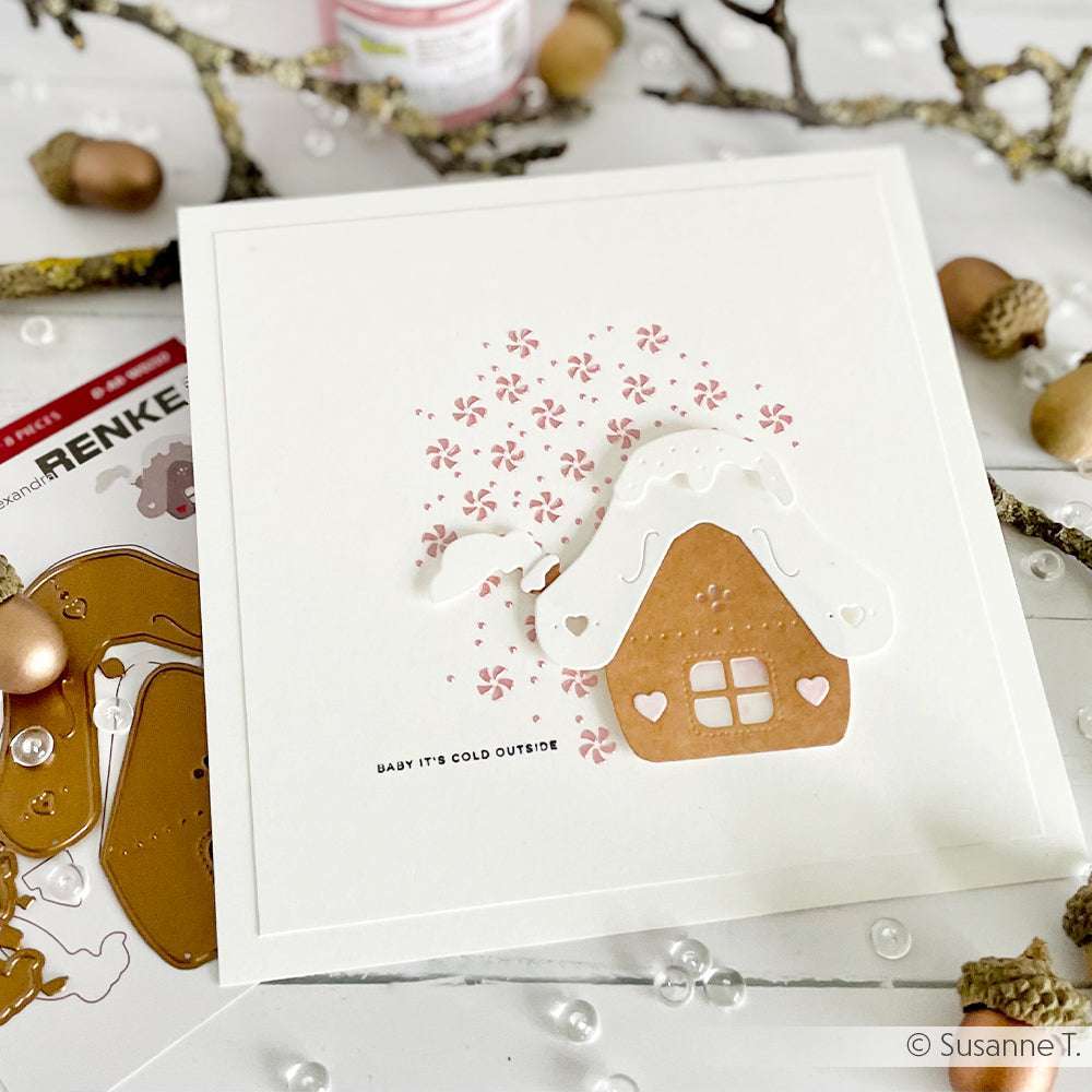 Eine handgefertigte Karte von Alexandra Renke mit einem Lebkuchenhaus, einem verschneiten Dach und dem Text "Baby it's cold outside" auf weißem Grund - perfekt für winterliche Papierprojekte oder zum Hinzufügen von Details mit Ihren Lieblingsschablonen und Schablonen.