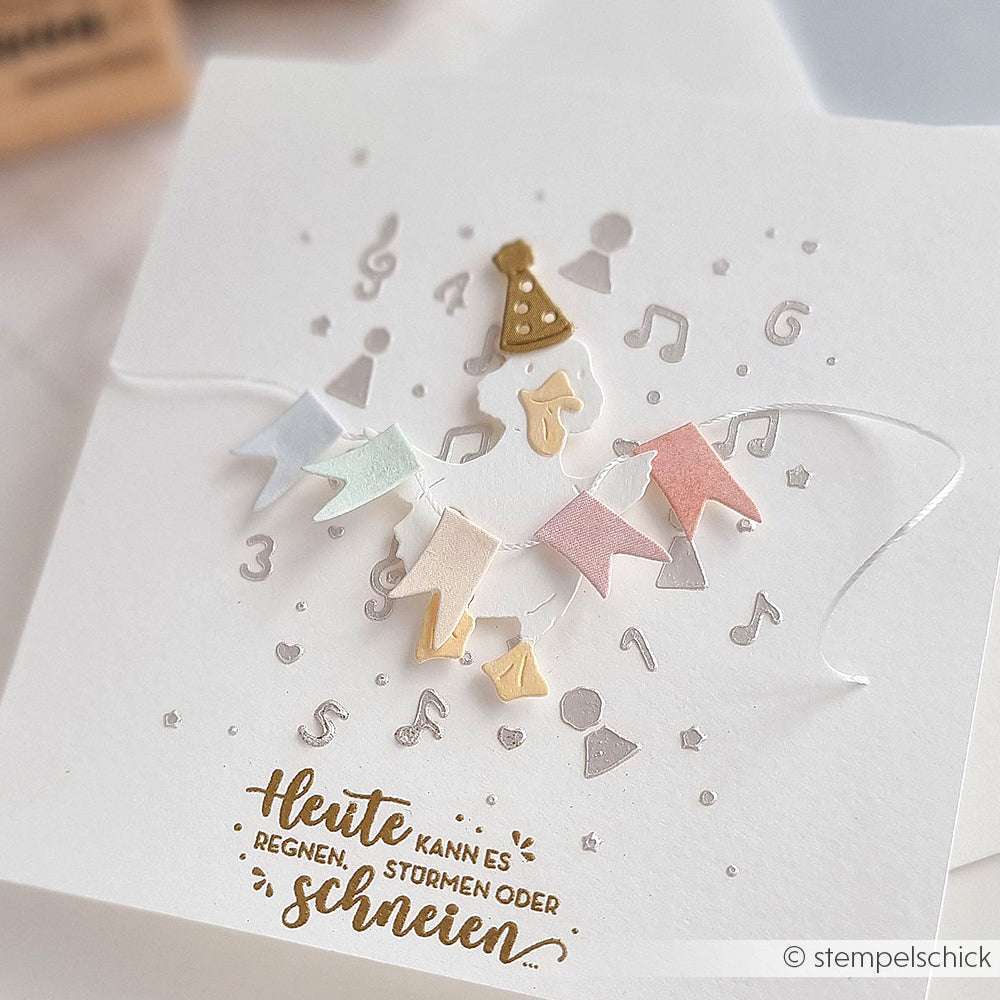 Handgefertigte Geburtstagskarte von Alexandra Renke mit pastellfarbenen Bannern, einem Partyhut, Musiknoten und goldfarbenem Text - hergestellt mit einer Schablone für präzise Muster. Perfekt für Papierprojekte-Fans.
