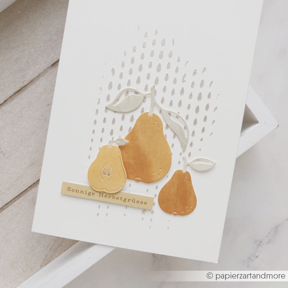 Handgefertigte Karte mit drei Birnen, Blättern und dem deutschen Text „Sonnige Herbstgrüße“ auf einem weißen, strukturierten Hintergrund – ideal für Schablonen-Papierprojekte und mit wiederverwendbaren Schablonen gestaltet, um zusätzliche Details zu erzielen.