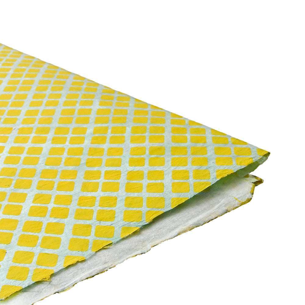 Ein Blatt ☆ strukturiertes Nepalpapier mit gelbem Rautenmuster auf weißem, leicht eingerissenem Rand - ideal zum Buchbinden oder Verpacken von Geschenken.