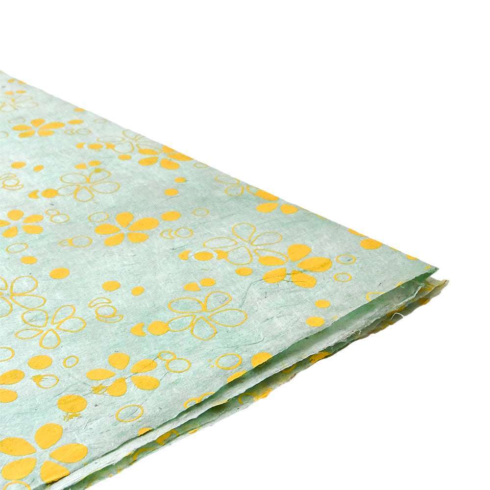 Blätter aus hellblauem Nepalpapier von ☆ mit gelben Blumenmustern, ideal zum Einpacken von Geschenken oder zum Buchbinden, dargestellt von der Seite auf weißem Hintergrund.
