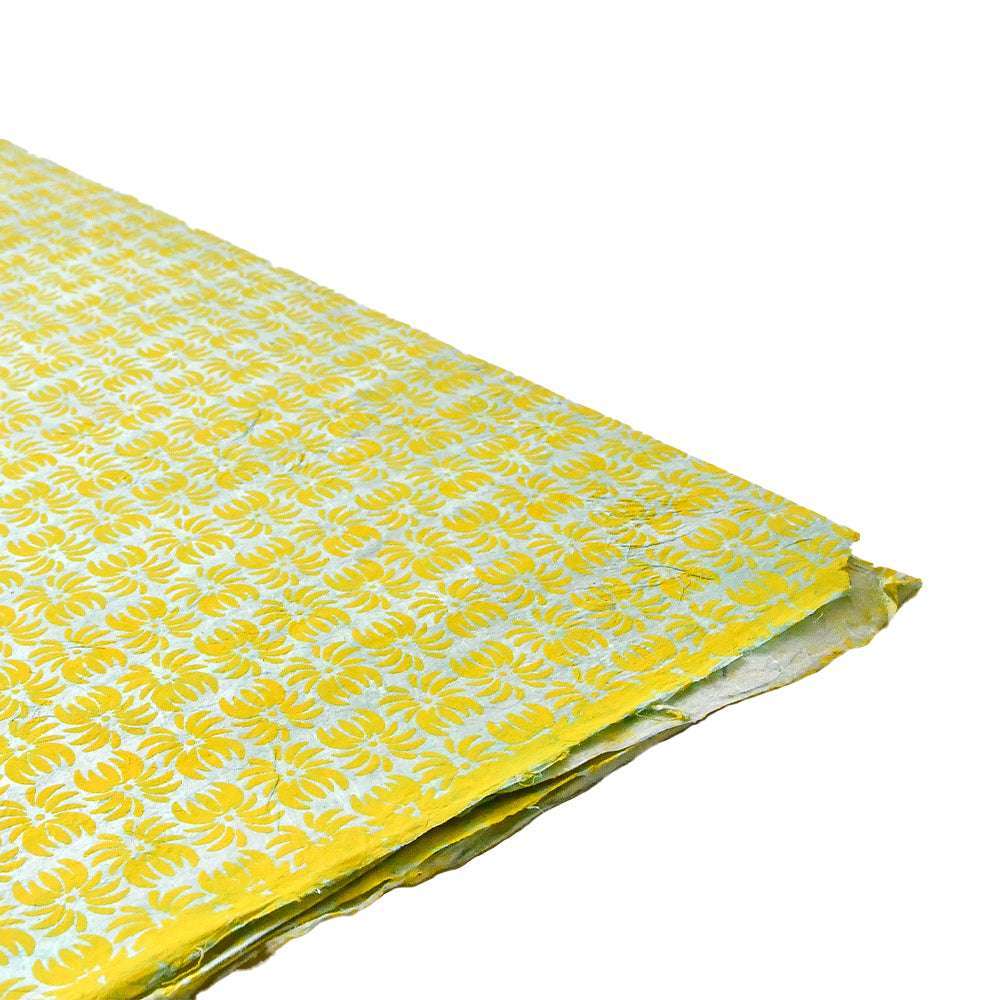 Ein Stapel dekoratives gelbes Nepalpapier von ☆, mit einem sich wiederholenden weißen Blumenmuster - ideal für Buchbinden oder Geschenke Verpacken.