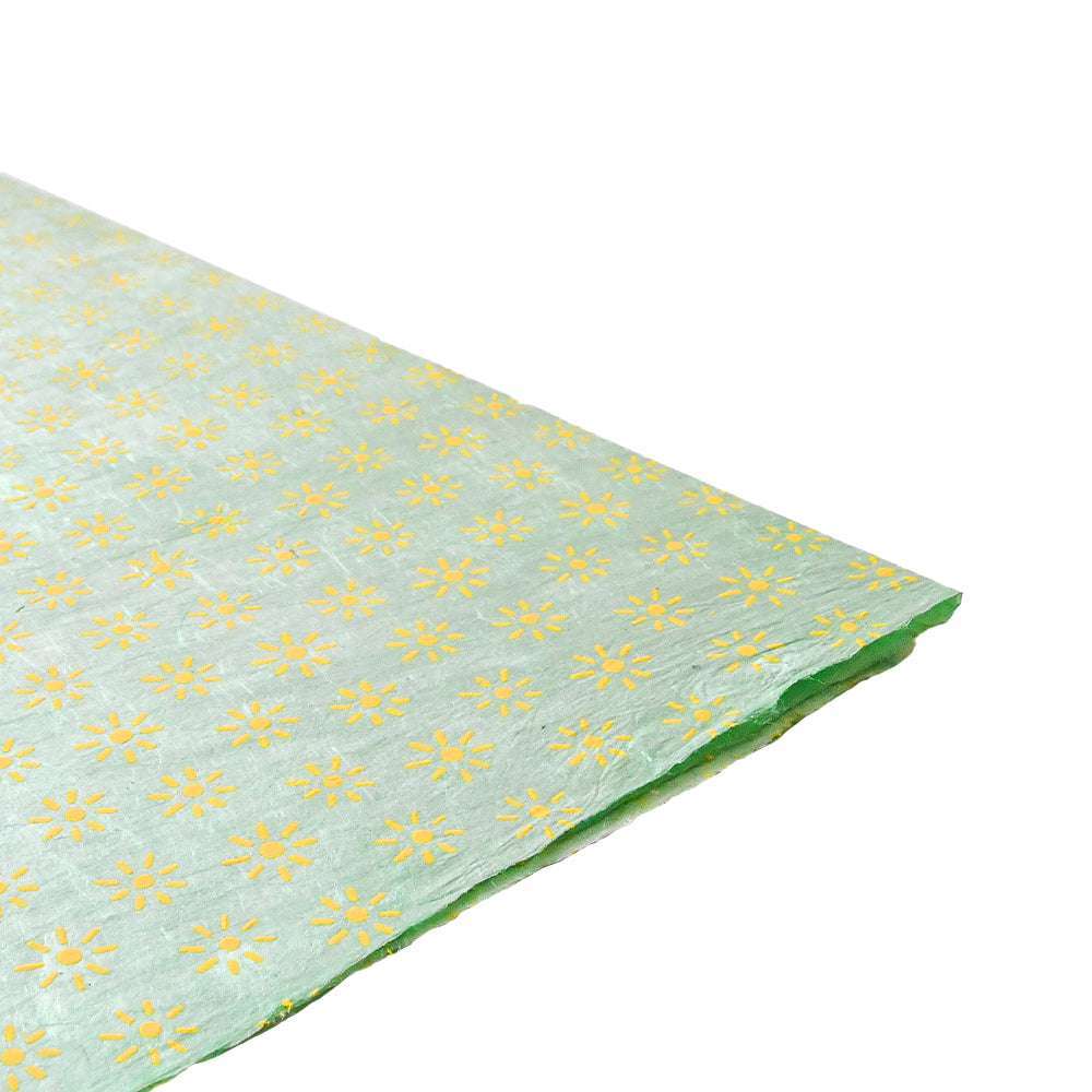 Ein hellgrünes Nepalpapier von ☆ mit gelben Gänseblümchen auf Weiß - ideal zum Buchbinden oder stilvollen Verpacken von Geschenken.