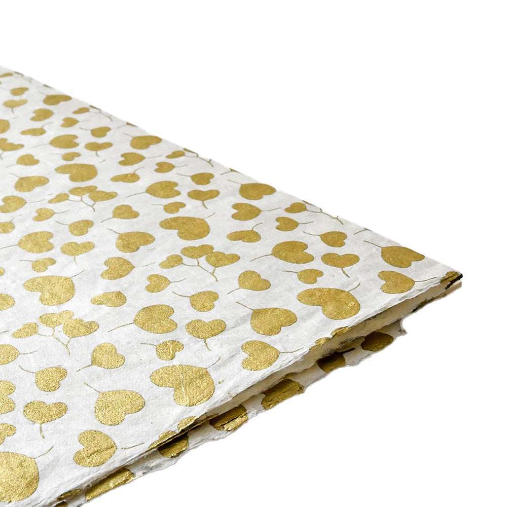☆ Nepalpapier in Weiß mit Goldfolienherzen, an der Ecke gefaltet - ideal zum Buchbinden oder Verpacken von Geschenken, auf weißem Hintergrund.