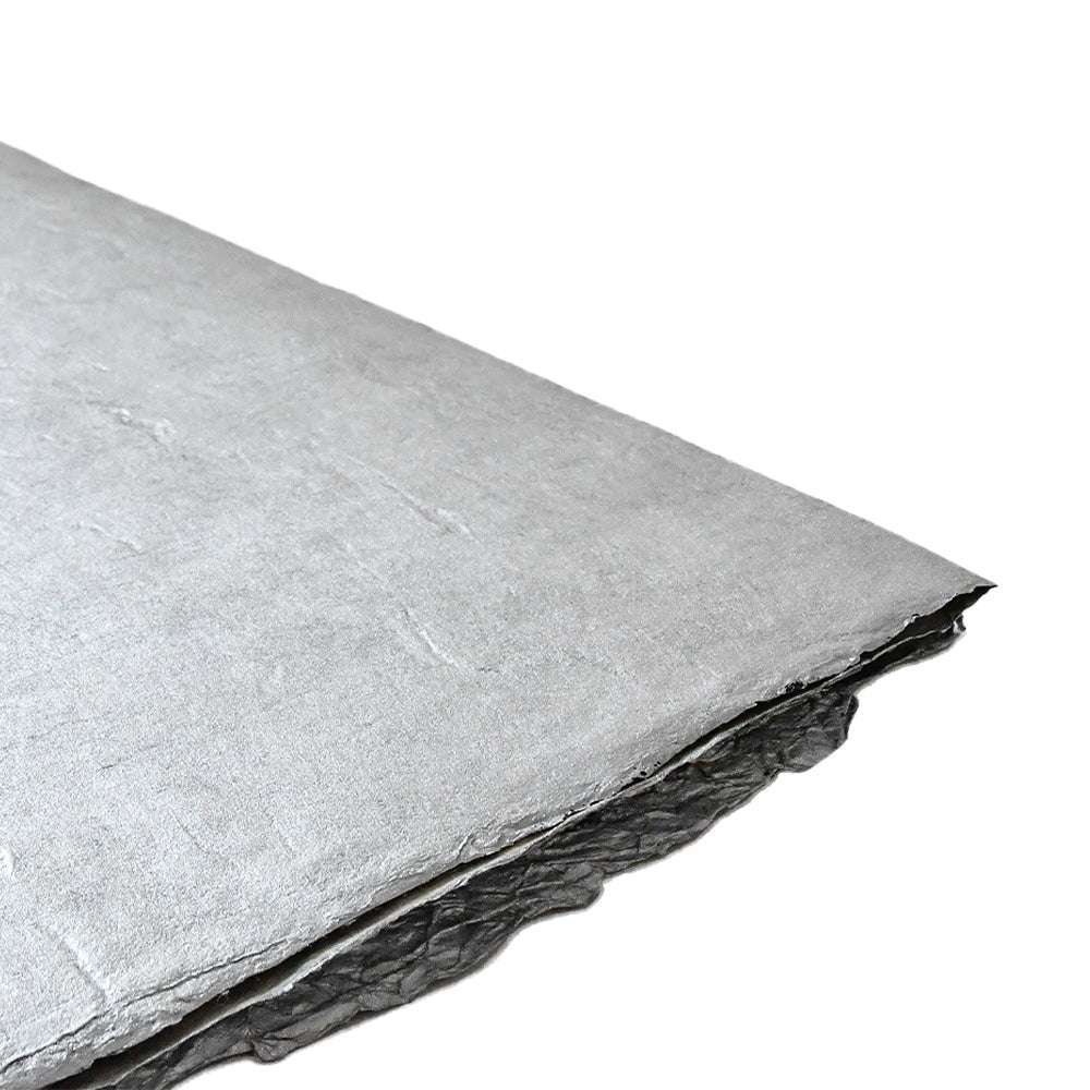 Eine Nahaufnahme einer Platte aus ☆ silberfarbenem Dämmstoff mit strukturierter Oberfläche, ähnlich Nepalpapier silber, ideal für Geschenke Verpacken und Buchbinden.
