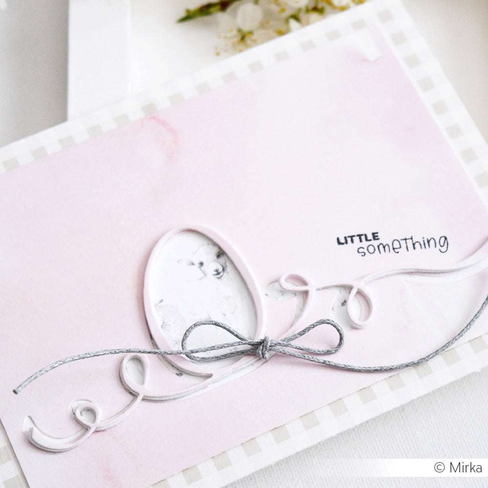 Eine rosafarbene Karte von Alexandra Renke mit einer silbernen Schleife aus DieCut Systemen, einem ovalen Ausschnitt und "LITTLE something" auf der Vorderseite.
