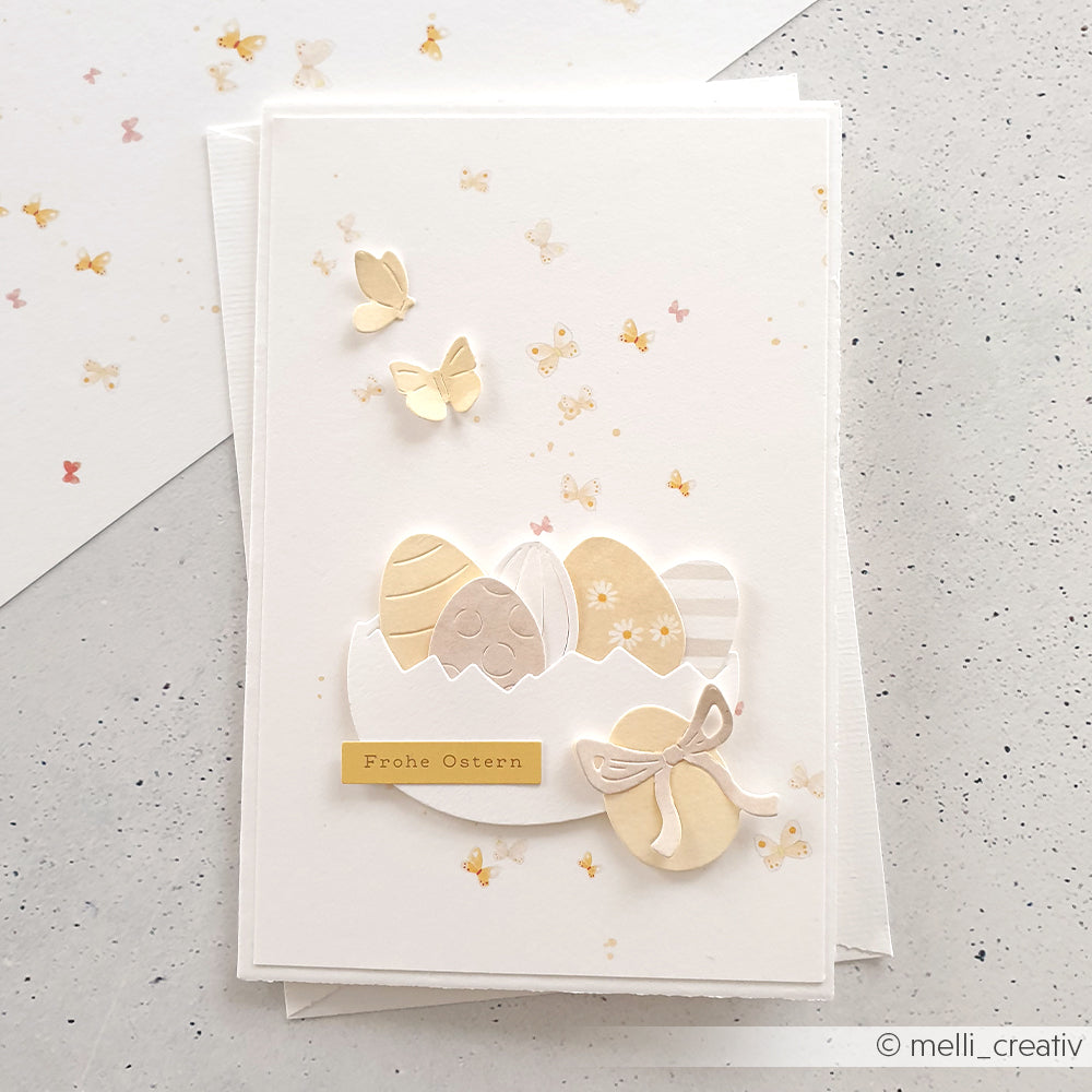 Osterkarte mit pastellfarbenen Eiern, Schmetterlingen und dem Schriftzug Frohe Ostern auf Weiß, gestaltet mit Alexandra Renke Designpapieren und dem Motivstanze Fröhliches Eier-Set für einen charmanten festlichen Touch.