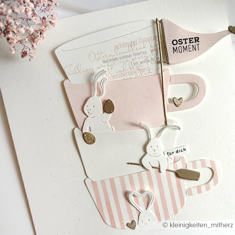 Drei pastellfarbene Teetassenausschnitte mit Hasen und Herzen, hergestellt mit der Alexandra Renke Motivstanze Ostern, dekoriert für Ostern auf einem weißen Hintergrund.