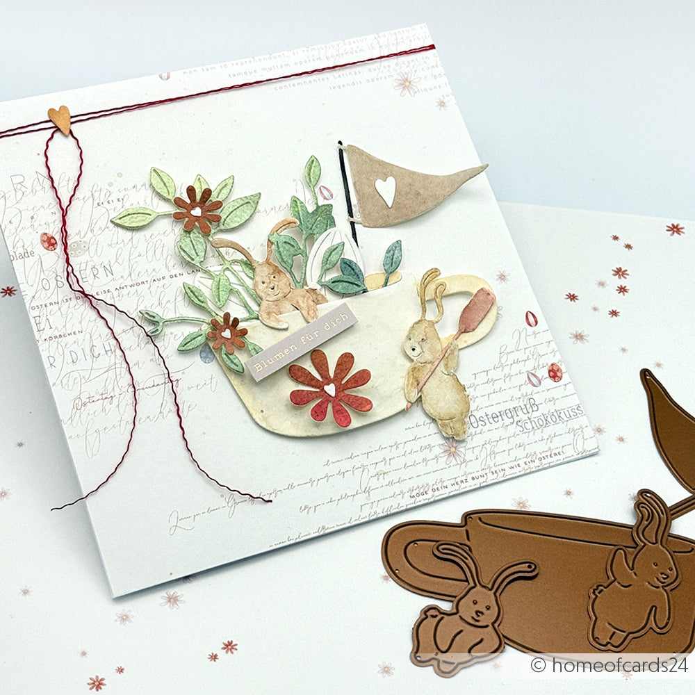 Handgefertigte Grußkarte zum Thema Hasen mit Kupferhasen-Stanzungen von Alexandra Renke, floralen Akzenten, einer Fahne und elegantem Designpapier auf einem strahlend weißen Hintergrund.