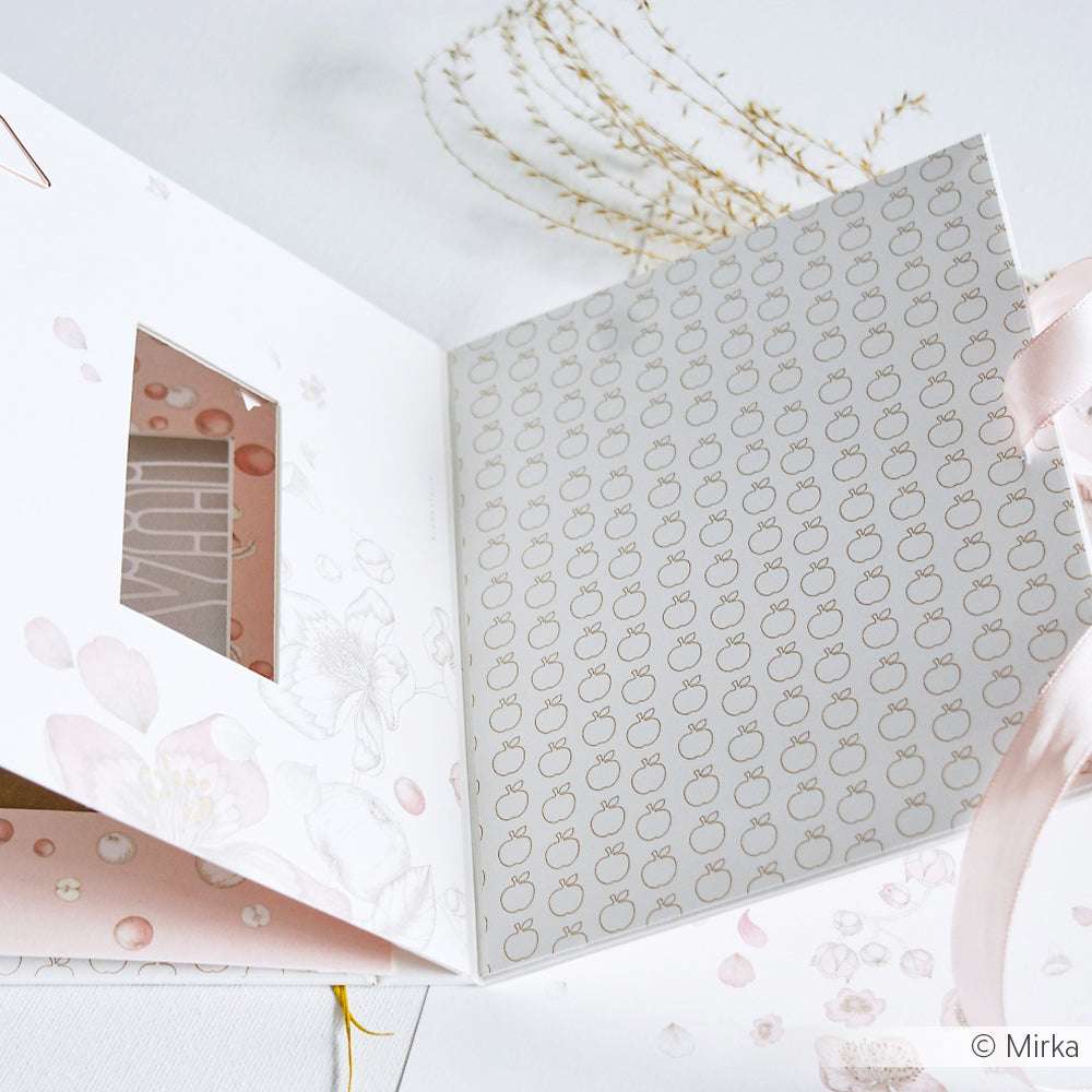 Elegante, florale Hochzeitseinladung von Alexandra Renke mit rosa Schleife und goldenen Äpfeln auf dem Innendeckel, gefertigt aus hochwertigem Designpapier und ausgestellt auf einer weißen Fläche.