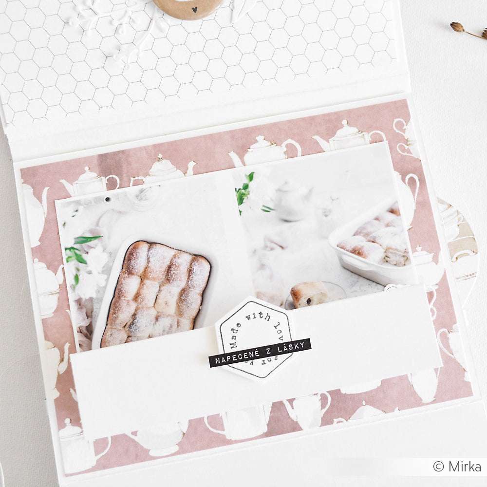 Geöffnetes Scrapbook mit Alexandra Renkes Foto von Gebäck, Designpapier mit Teekannenmotiv und einem Etikett "Made with Love" - die perfekte Inspiration für Ihr nächstes Papierprojekt.