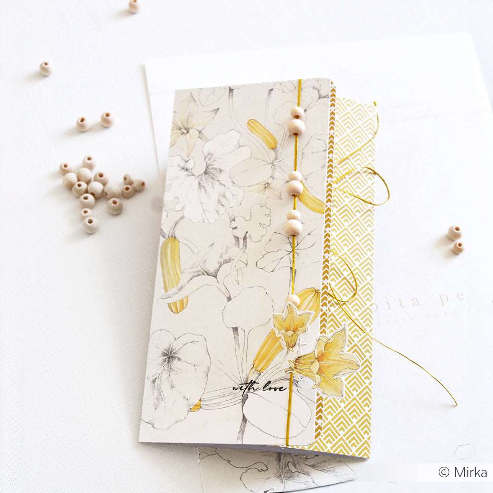 Handgemachte Blumenkarte von Alexandra Renke mit gelben Akzenten und Perlen, hergestellt aus hochwertigem Designpapier, auf weißem Papier mit verstreuten Holzperlen.