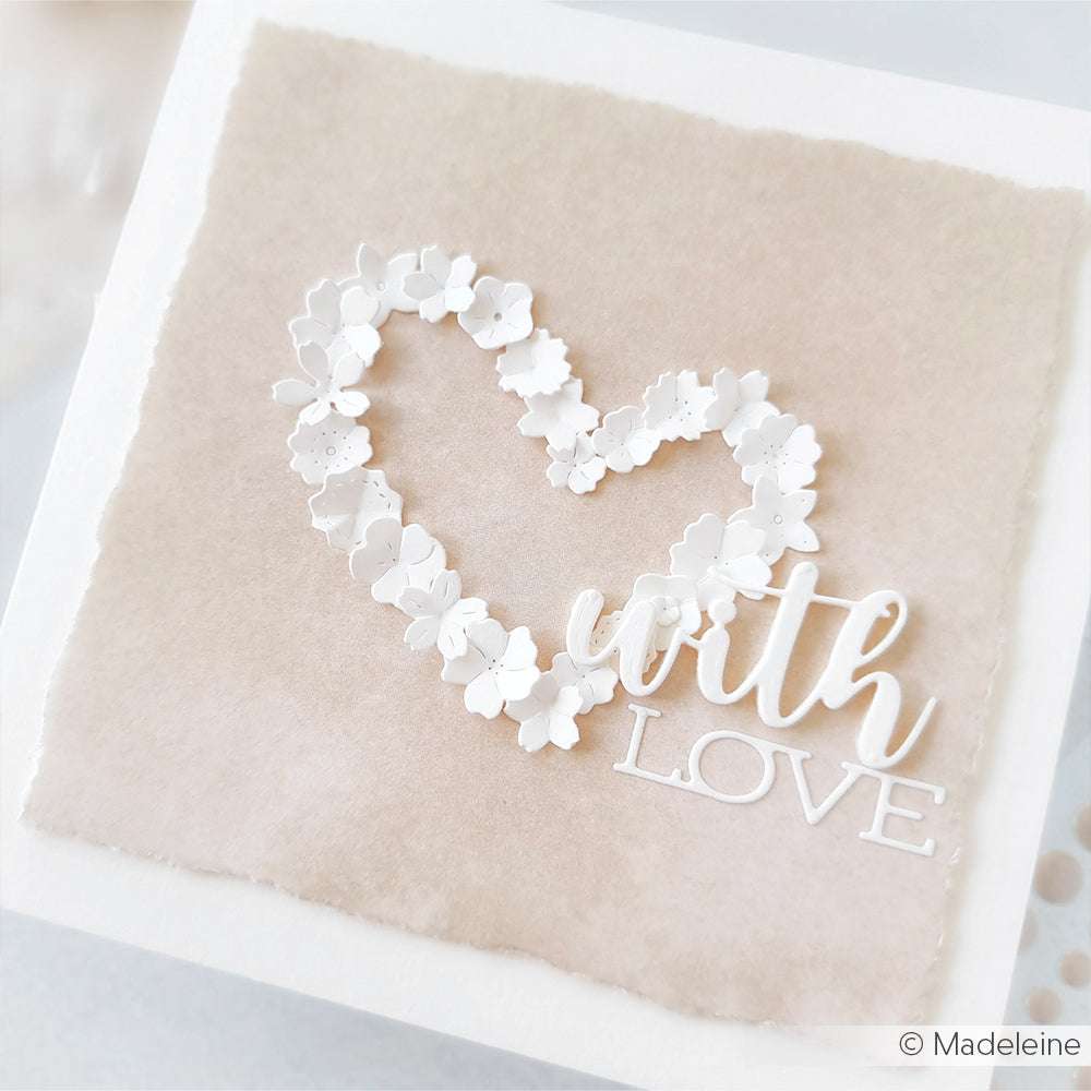 Ein Herz aus weißen Papierblumen von Alexandra Renke's Designpapier mit dem Text "with love" auf einem beigefarbenen strukturierten Hintergrund - ideal für Papierprojekte oder Buchbinderei.