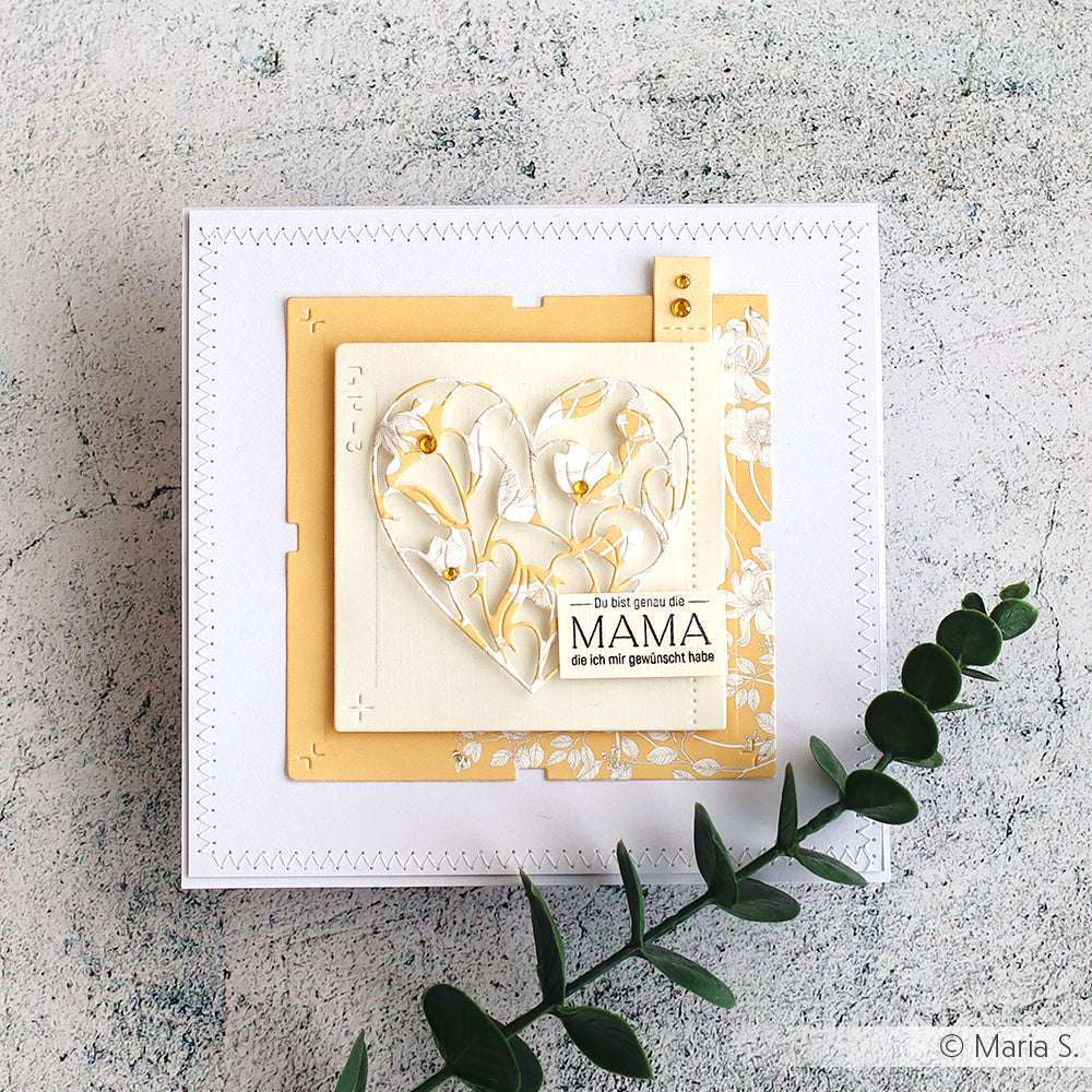 Handgemachte Karte von Alexandra Renke mit einem Blumenherz, gelben Akzenten, deutscher Botschaft, gestaltet mit gemustertem Papier und weißen Blumen auf einer weißen Fläche mit Grün.