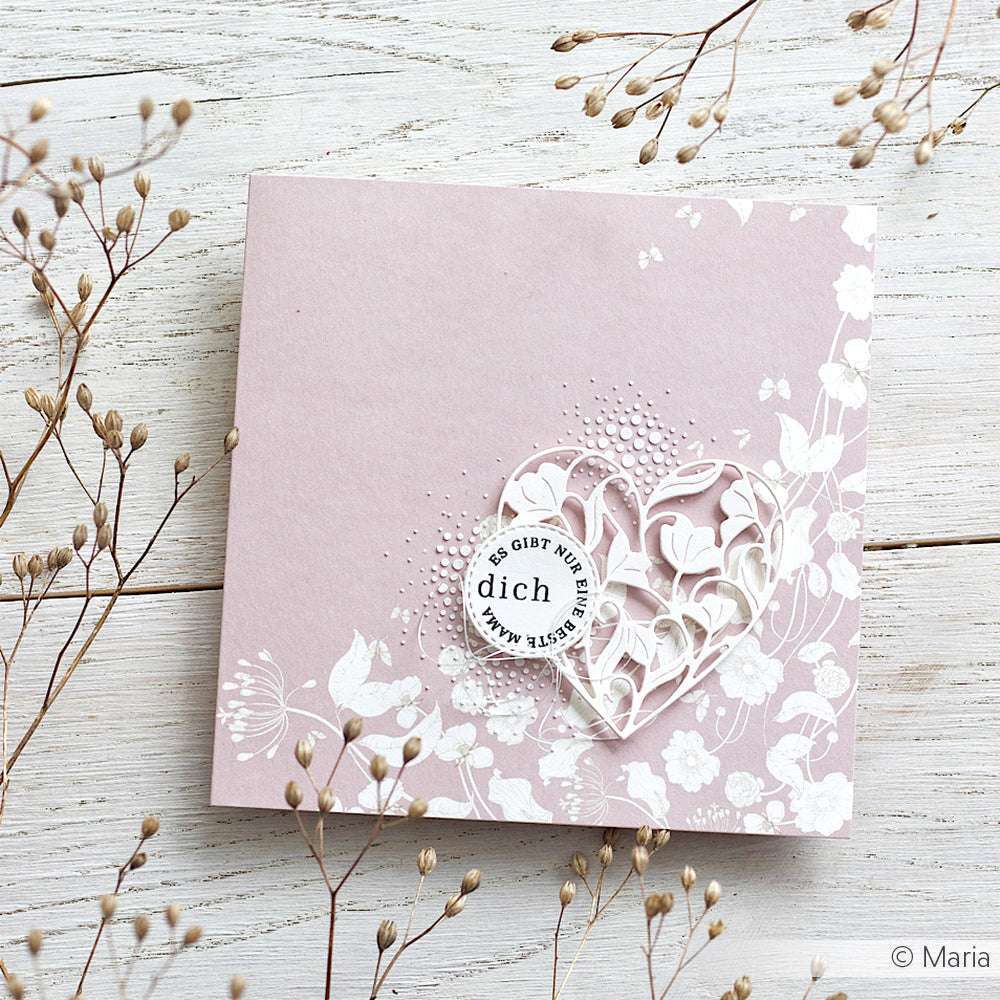 Alexandra Renke rosa Blumengrußkarte mit einem Spitzenherz, umgeben von einer zarten weißen Blumenvariation aus getrockneten Blumen auf einer weißen Holzoberfläche - ideal für Papierprojekte oder kreatives Designpapier geeignet.