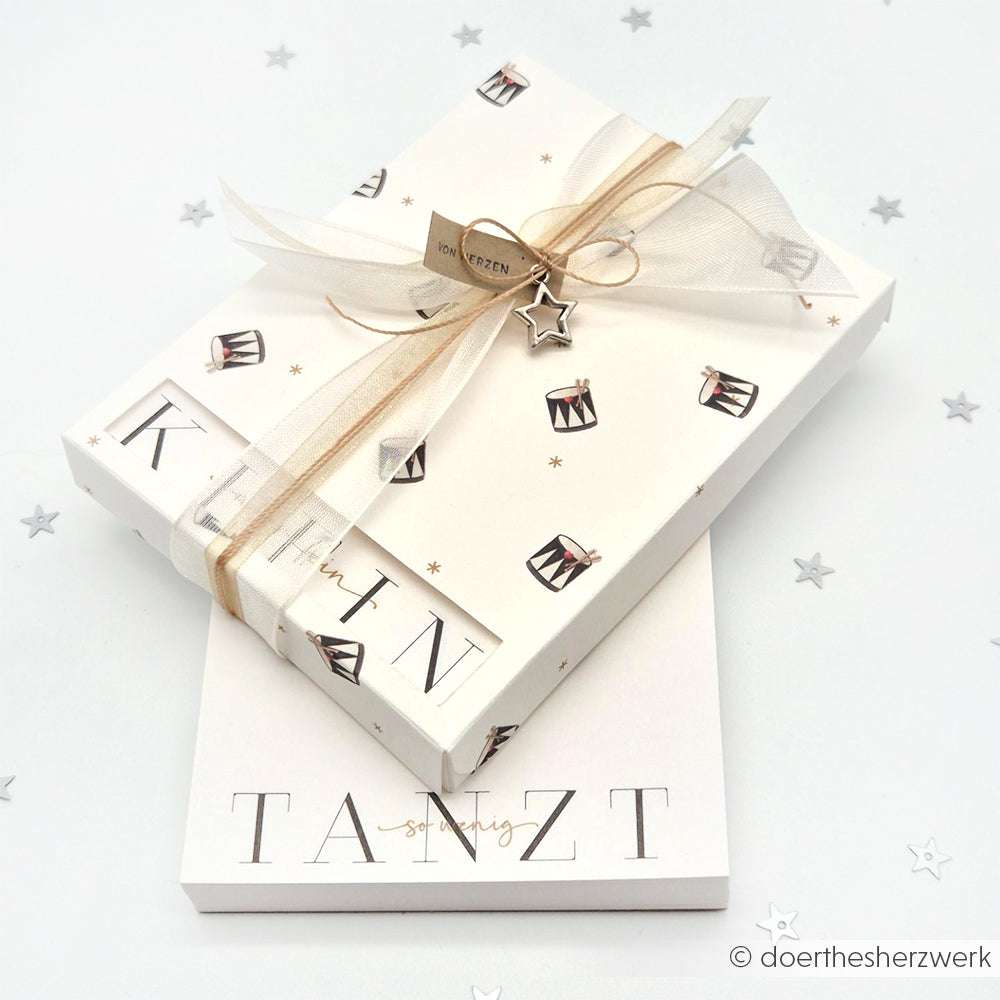 Eine weiße Geschenkbox mit Schleife und Band von Alexandra Renke, ideal für Papierprojekte oder zum Verpacken von Geschenken aus elegantem Designpapier.