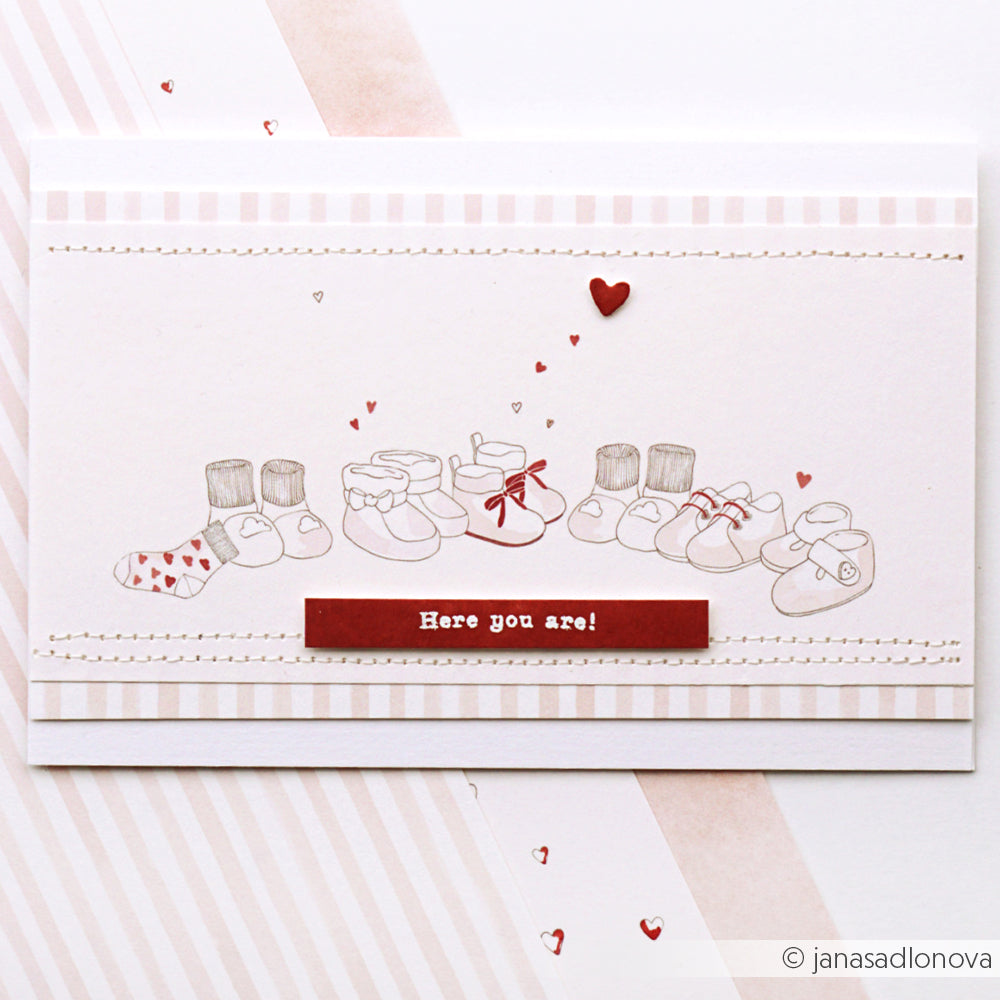 Illustration von sechs Paar Babyschuhen und Socken mit einem roten "Here you are!"-Etikett und kleinen Herzen - perfekt für Papierprojekte oder Designpapier. Inspiriert von Zwergenwäsche hellrosa von Alexandra Renke für einen süßen, zarten Touch.