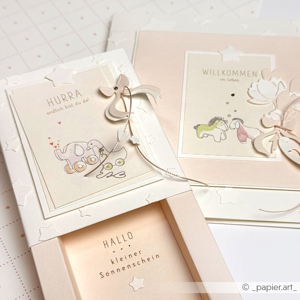 Zwei pastellfarbene Grußkarten von Alexandra Renke mit niedlichen Tierillustrationen und zarten Details. Mit hochwertigem Designpapier hergestellt, sind diese charmanten Karten perfekt für Babygrüße und besondere Anlässe.