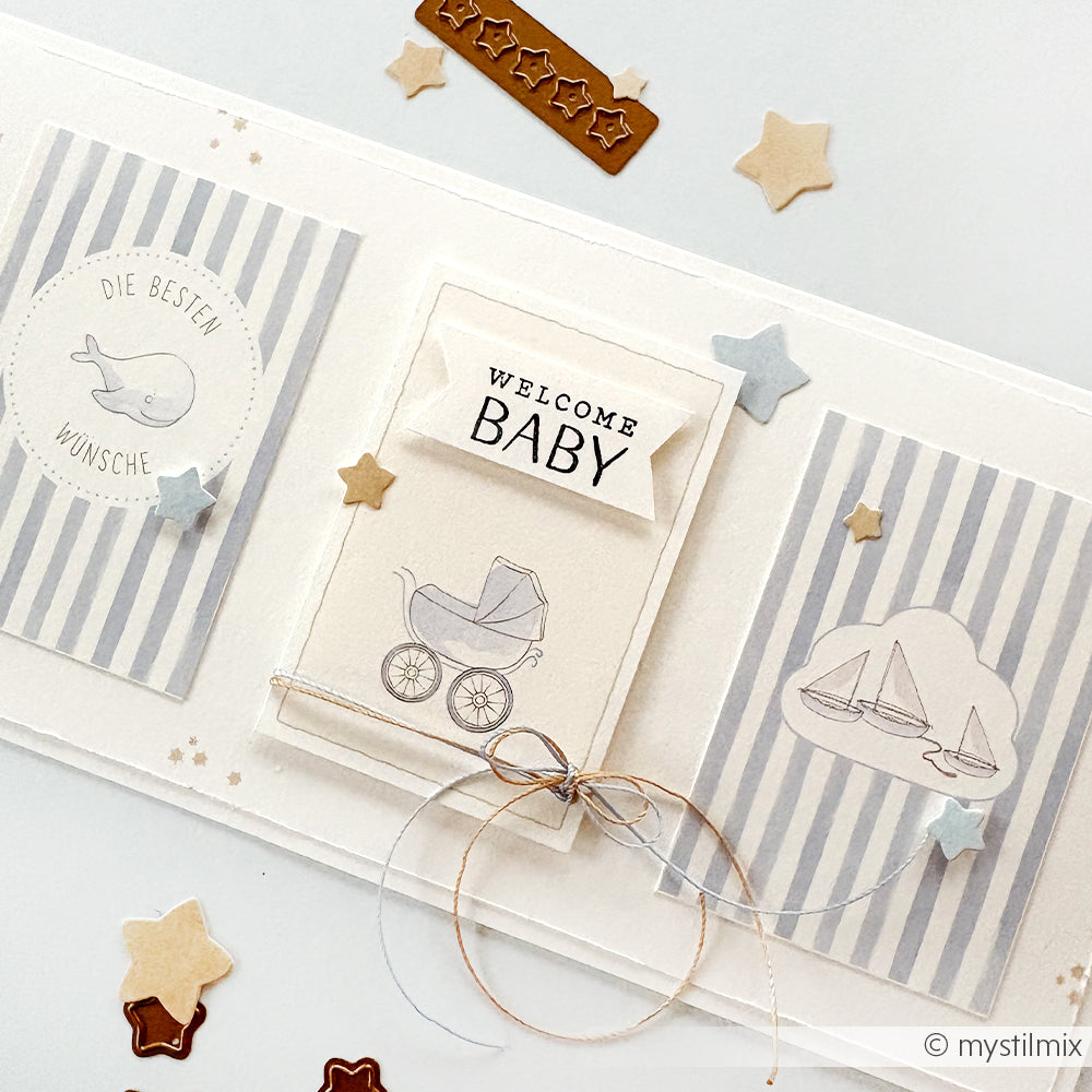 Eine handgefertigte Grußkarte von Alexandra Renke mit dem Text "Welcome Baby", einem Kinderwagen, Sternen und gestreiftem, pastellfarbenem Designerpapier - perfekt, um Neuankömmlinge zu feiern.