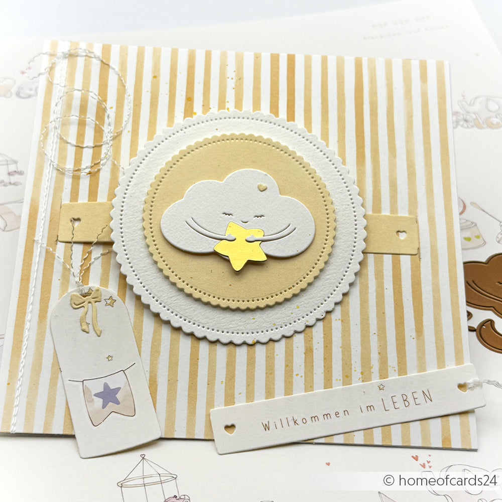 Handgefertigte Karte von Alexandra Renke mit einer lächelnden Wolke, einem goldenen Stern, Streifen senfgelb im Hintergrund und dem deutschen Text "Willkommen im LEBEN".