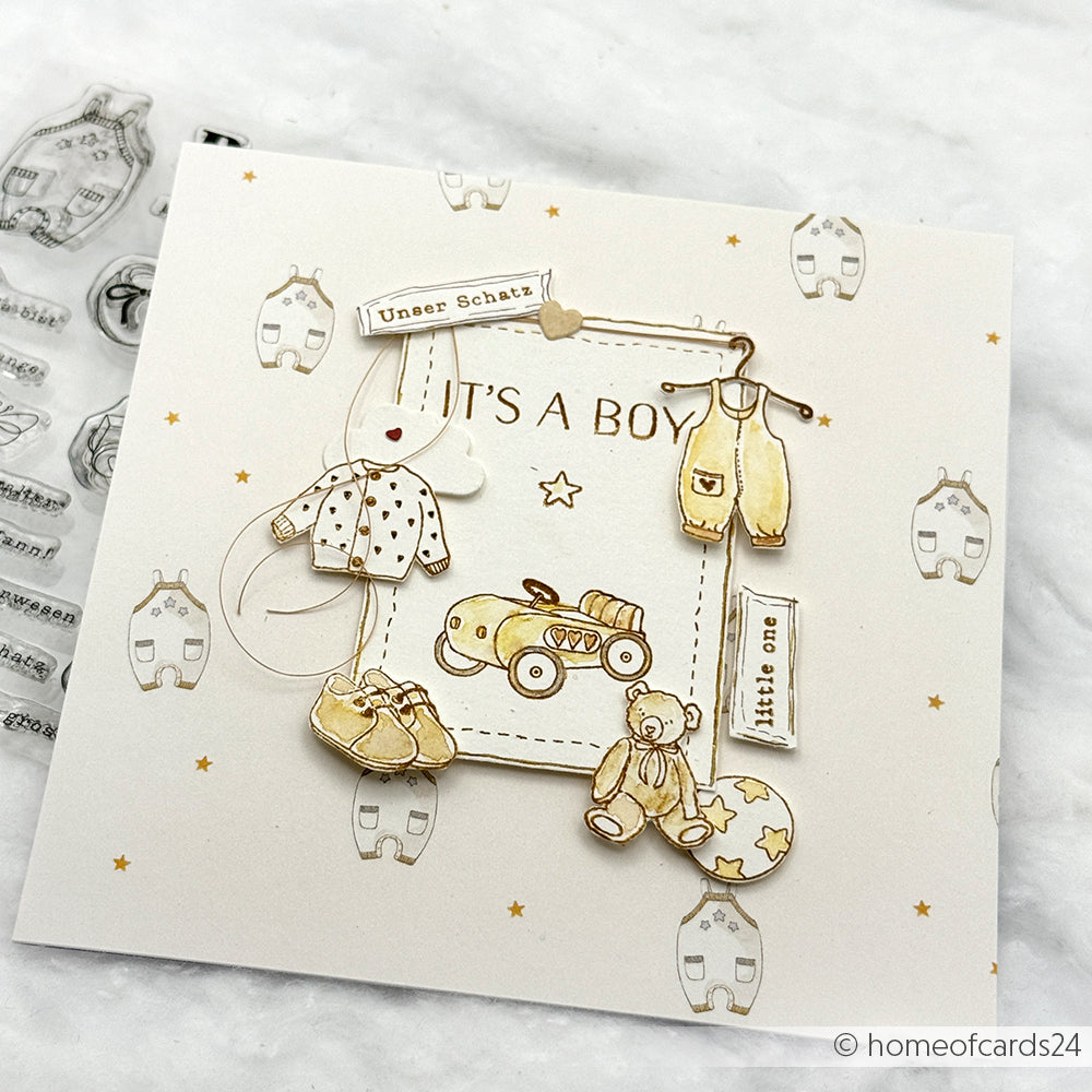Handgemachte Grußkarte von Alexandra Renke mit Babykleidung, Spielzeug, "It's a Boy"-Text, Sternen und sanften Farben - ideal für Papierprojekte oder zum Kombinieren mit Ihrem Lieblingsdesignpapier.