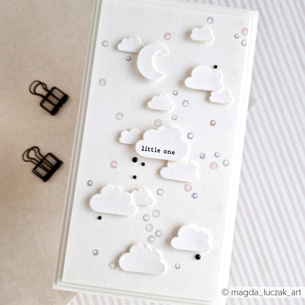 Weiße Karte von Alexandra Renke aus Designpapier mit erhabenen Wolken, einer Mondsichel und einem "Kleinen" zwischen pastellfarbenen Punkten - ideal für Papierprojekte oder Buchbinderei-Kreationen.