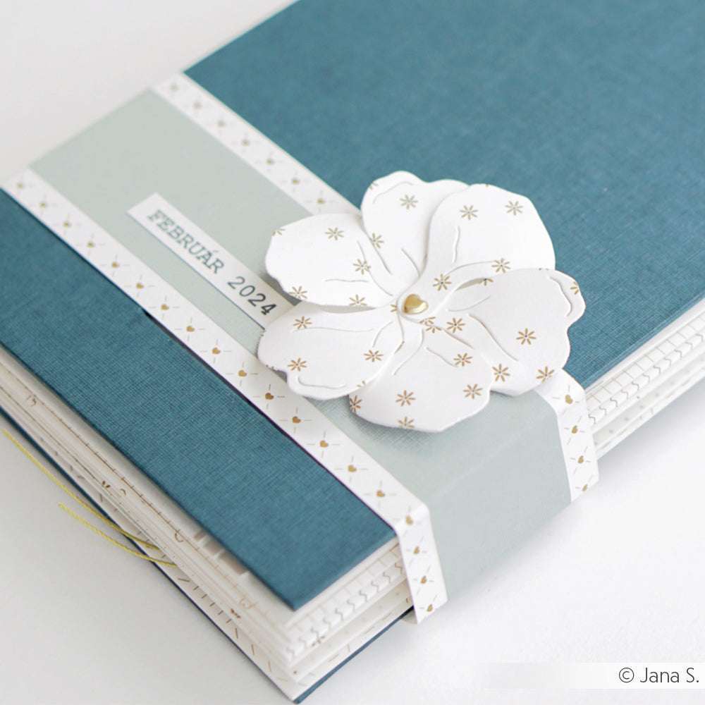 Blaues ☆ Journal mit FSC-zertifiziertem Einband, einer weißen Papierblume und dem Etikett "Februar 2024". Hergestellt aus hochwertigem 120g/m² Papier.