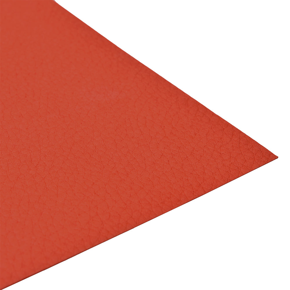 Eine Nahaufnahme eines strukturierten, roten, diagonal angeordneten ☆ Kartonbogens mit lederähnlicher Oberfläche.