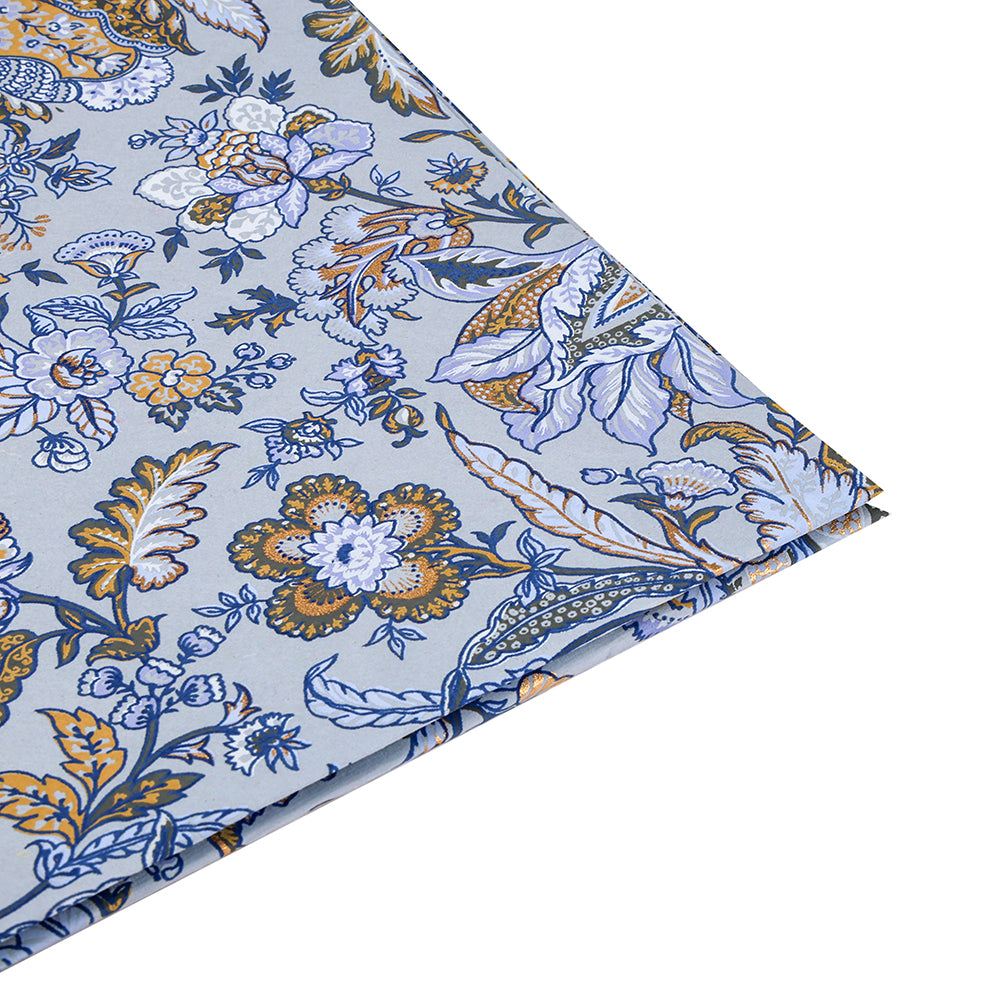 Gefalteter Stoff von ☆ mit einem blauen, goldenen und weißen Blumenmuster auf hellblauem Grund, schräg gezeigt - ideal für Geschenke Verpacken oder um Ihren Projekten Handarbeits-Flair zu verleihen.
