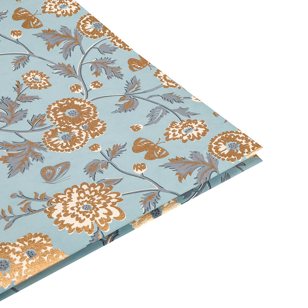 ☆ Blaues Baumwollpapier mit goldenem und braunem Blumenmuster, abgebildet mit einer gefalteten Ecke auf Weiß - ideal zum Verpacken von Geschenken oder um Ihren Bastelarbeiten eine besondere Note zu verleihen.