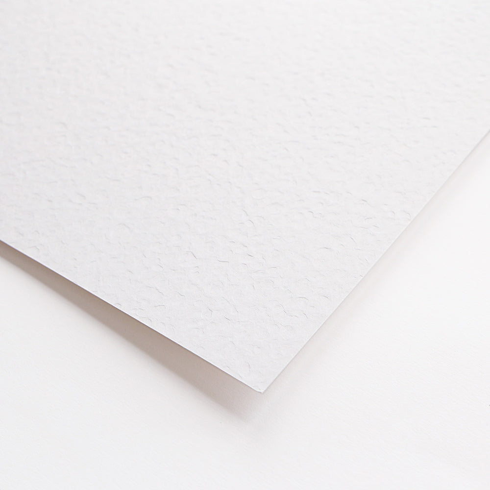 Nahaufnahme eines Blattes strukturiertes Alexandra Renke Naturpapier auf einer weißen Fläche.