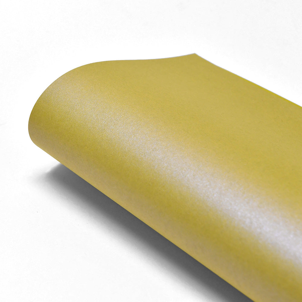 Ein Blatt ☆ gelbes Sandpapier, das an Schimmer Effekt Papier erinnert, kräuselt sich anmutig auf einer weißen Fläche.