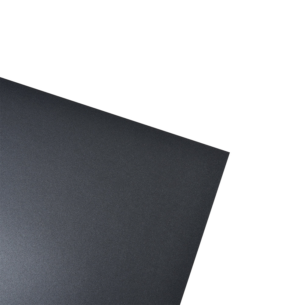 Ein schwarzes rechteckiges ☆ Bastelpapier 250g/m² wird diagonal auf einen weißen Hintergrund gelegt.