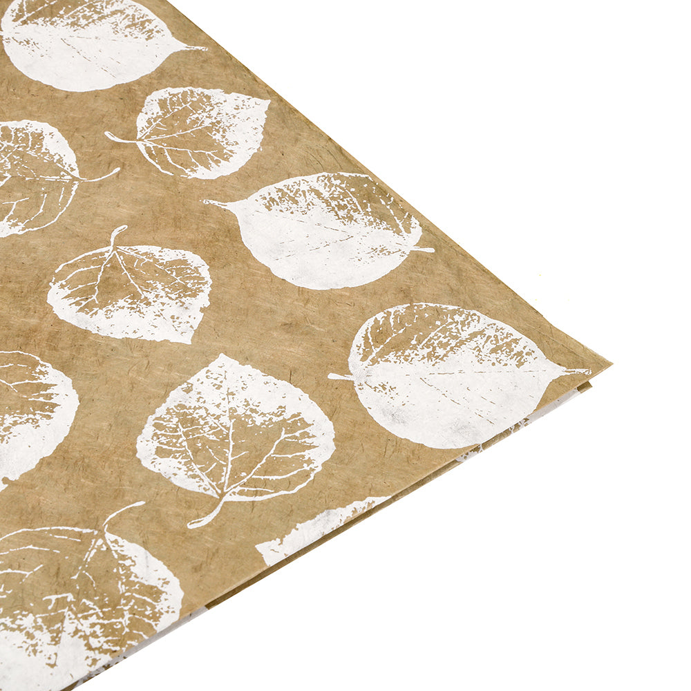 Braunes Nepalpapier von ☆ mit weißem Blattdruck, schräg auf weißem Hintergrund - perfekt für nachhaltige Geschenkverpackungen.