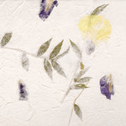 ☆ Handgeschöpftes Papier mit grünen Blättern sowie gepressten lila und gelben Blüten auf weißer Textur - perfekt für Geschenkverpackungen oder kreative Projekte.