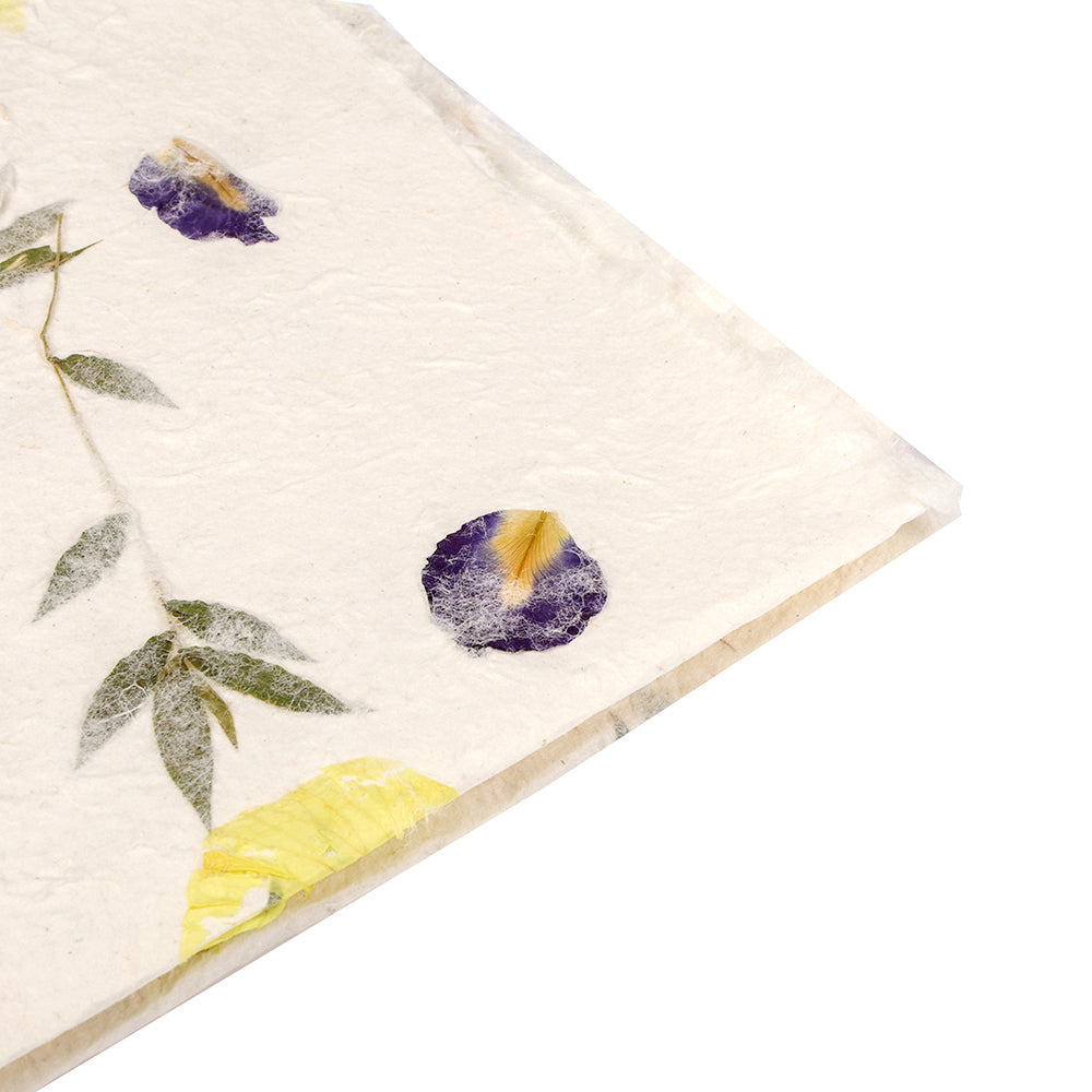 Handgeschöpftes Papier von ☆ mit gepressten lila und gelben Blüten sowie grünen Blättern in strukturierter Oberfläche - ideal zum Geschenke Verpacken oder für kreative Projekte.