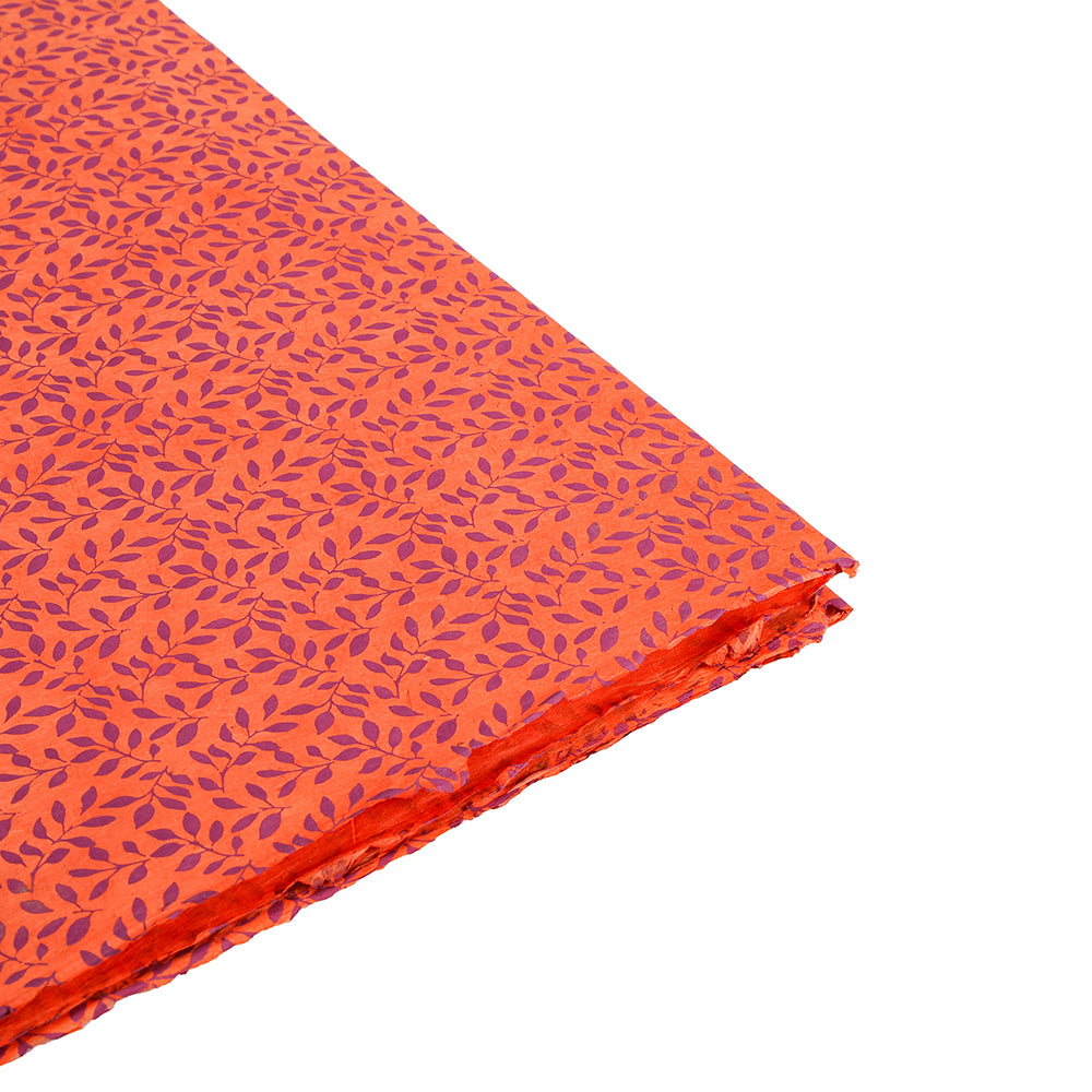 Gefaltetes orangefarbenes Nepalpapier von ☆ mit kleinem lila Blattmuster auf weiß-idealem nachhaltigem Papier für Geschenke Verpacken.