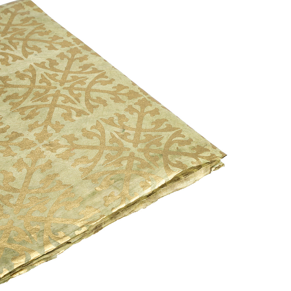 Gefaltetes Nepalpapier in Gold und Beige mit einem verschnörkelten, sich wiederholenden Muster auf weißem Hintergrund - ideal für Geschenkverpackungen oder andere Projekte, für die nachhaltiges Papier benötigt wird.